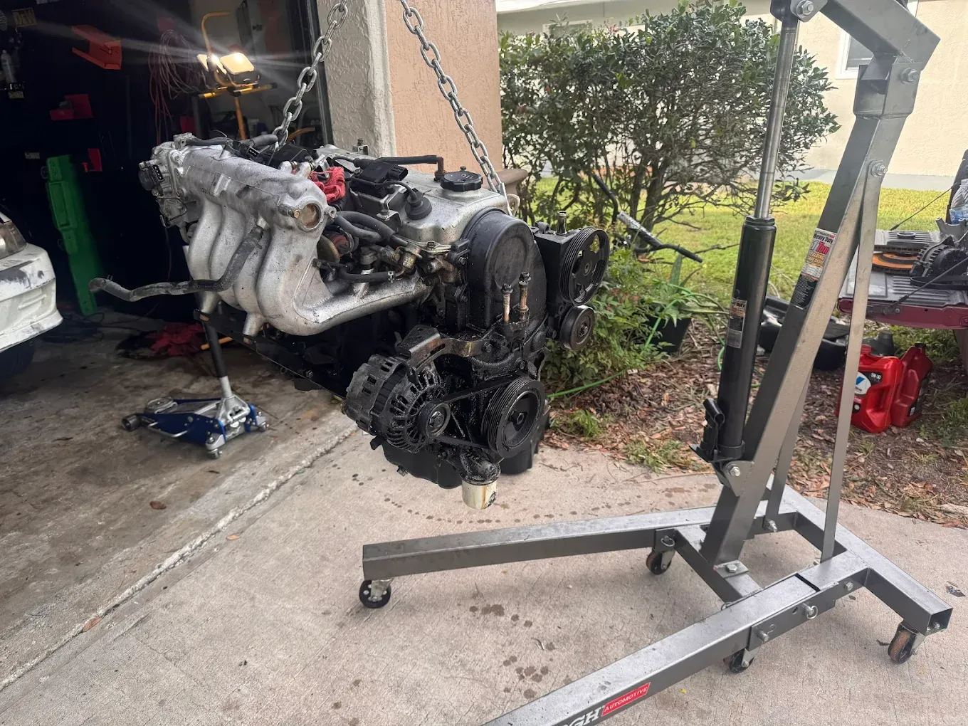 Engine pulled and hanging on a hoist at the C&C shop